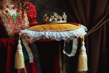 Wall Mural - Closeup on medieval queen in red dress with crown on pillow