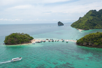 Aerial view of boats with clear blue separated island, turquoise seawater, Andaman sea in Phuket island in summer season, Thailand. Water in ocean material pattern texture wallpaper background.