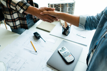 Wall Mural - Two engineers shaking hand after working successful about brainstorming about construction project