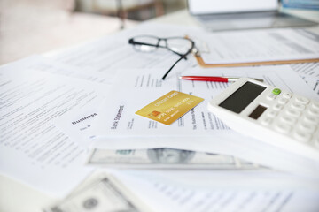 Wall Mural - Close-up view, credit card with bank statement with other work document and dollar on desk, Calculating credit card expenses and paying them