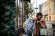 © Marko Geber - Young interracial lesbian couple shopping and using a phone in the city