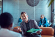 © Marko Geber - Two coworkers talking in the lobby of a modern business office of a startup company
