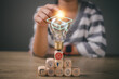 © FAMILY STOCK - Hands-touching light bulb with graduation hat on wooden cubes stacked, Internet education course degree, E-learning graduate certificate program concept. study knowledge to creative thinking ideas.
