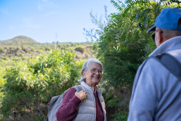 Sticker - Happy caucasian senior couple in outdoors excursion in mountain foothpath enjoying freedom in nature. Active and healthy lifestyle in retirement