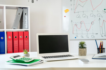 Poster -  wooden table with laptop pc monitor pen andd other, whiteboard with business graph on wall