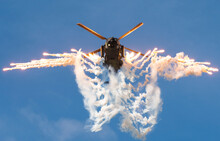 Military Helicopter Firing A Series Of Flares In A Defensive Manoeuvre