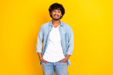 Photo of cheerful charming guy dressed denim jacket smiling walking isolated yellow color background