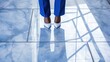 Businesswoman's reflection in a polished blue and white marble floor