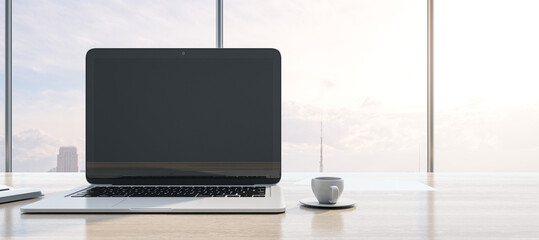 Poster - Close up of modern workspace with empty mock up laptop screen, supplies, coffee cup and panoramic window with city view in the background. 3D Rendering.