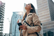 © Westend61 - Young woman with eyes closed holding coffee cup and smart phone in city