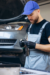 Wall Mural - Auto mechanic using wrench and other tools on car service