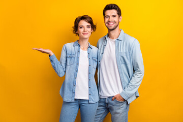 Sticker - Photo of cute sweet positive couple wear stylish denim clothes presenting empty space black friday offer isolated yellow color background