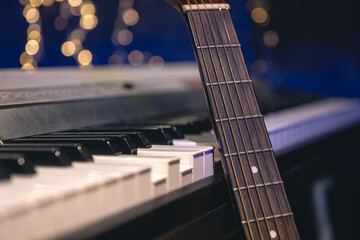 Wall Mural - Guitar and piano keys close-up on a blurred background with bokeh.