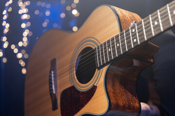 Wall Mural - Close-up, acoustic guitar on a dark background with bokeh lights.