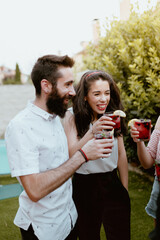 Group of cheerful friends clinking glasses at party