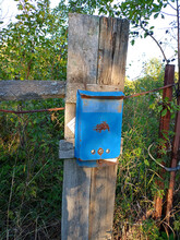 Abandoned Old Rusty Russian Metal Mailbox On A Destroyed Fence In A Village With An Electricity Bill Receipt. Vertical Photo