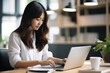 © koala studio - Asian businesswoman working on laptop in office