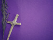 Christianity concept about Good Friday, Lent Season and Holy Week. Background of a dry palm leaf and a Holy Cross made of palm leaf on blurred purple background.