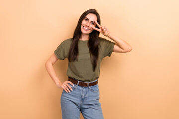 Sticker - Photo of sweet shiny girl dressed khaki t-shirt showing v-sign cover eye isolated beige color background