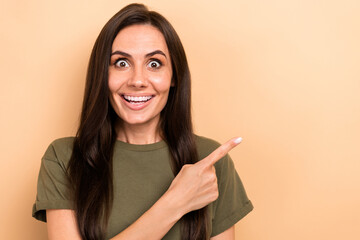 Sticker - Photo of impressed woman with straight hairdo dressed khaki t-shirt indicating at offer empty space isolated on beige color background