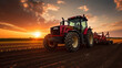 © Yuwarin - Red big tractor parked on the field in the sunset.