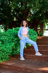 White young woman wearing a casual outfit posing for the camera while standing on the stairs