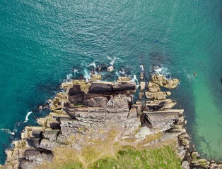 Poster - Aerial view of green cliffs facing the sea in the morning