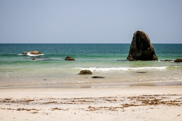 Poster - Tranquil sea with rocks at Black Beach, Praia Preta, Brazil.