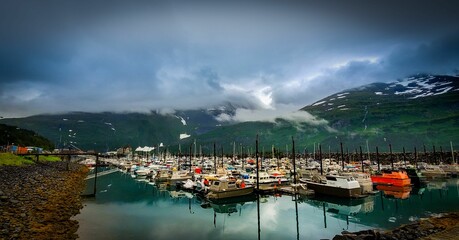 Wall Mural - Harbor with ships on a cloudy day and mountainous view