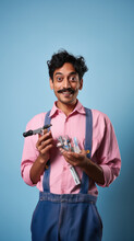 Indian man holding pocket size electric tools and giving shocking expression.