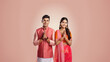 Indian couple in traditional wear and doing namaste or welcome gesture.