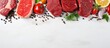 © AkuAku - Top view of organic food a banner with raw meat including steak salmon beef and chicken displayed on a white wooden background