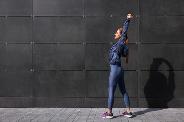 Poster - Beautiful woman in gym clothes doing exercises on street, space for text