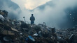 man on a huge mountain of trash and discarded clothes