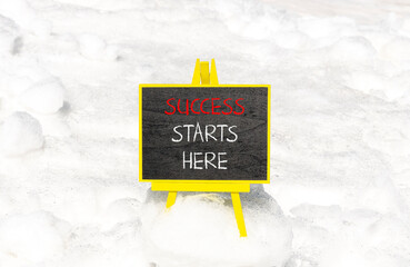 Wall Mural - Success starts here symbol. Concept word Success starts here on beautiful black blackboard. White snow. Beautiful white snow background. Business motivational success starts here concept. Copy space.