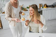 © LIGHTFIELD STUDIOS - cropped view of two sisters looking at cupcakes and smiling on kitchen backdrop, family bonding