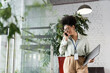 © LIGHTFIELD STUDIOS - joyful african american businesswoman in glasses holding laptop and talking on smartphone in office