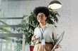 © LIGHTFIELD STUDIOS - portrait of happy african american businesswoman in glasses holding laptop and smartphone in office