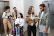 © LIGHTFIELD STUDIOS - inclusion and diversity, happy multiethnic team standing together near office elevators in hall