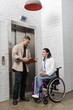 © LIGHTFIELD STUDIOS - inclusion and diversity, asian man holding startup plan near disabled woman and office elevators