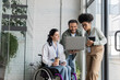 © LIGHTFIELD STUDIOS - group shot of diverse business people, disabled woman on wheelchair looking at laptop with coworkers