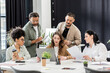 © LIGHTFIELD STUDIOS - interracial business team generating ideas and discussing project in modern coworking, using laptop