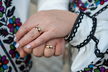 Wall Mural - close-up view of a young couple holding hands in embroidered traditional Ukrainian clothes