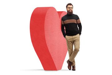 Wall Mural - Full length portrait of a bearded man leaning on big red heart