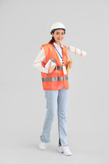 Sticker - Female decorator with paint and roller on light background