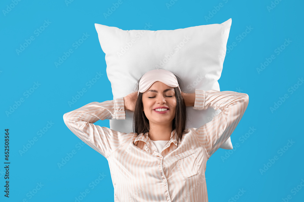 Pretty young woman sleeping on blue background