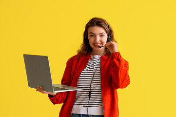 Wall Mural - Female technical support agent with laptop on yellow background