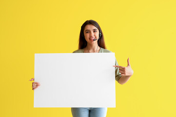 Wall Mural - Female technical support agent with blank poster on yellow background