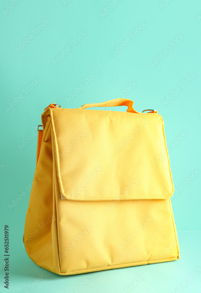 Yellow lunch box bag on turquoise background