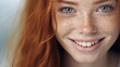 Closeup portrait of a young smiling redhead woman with freckles